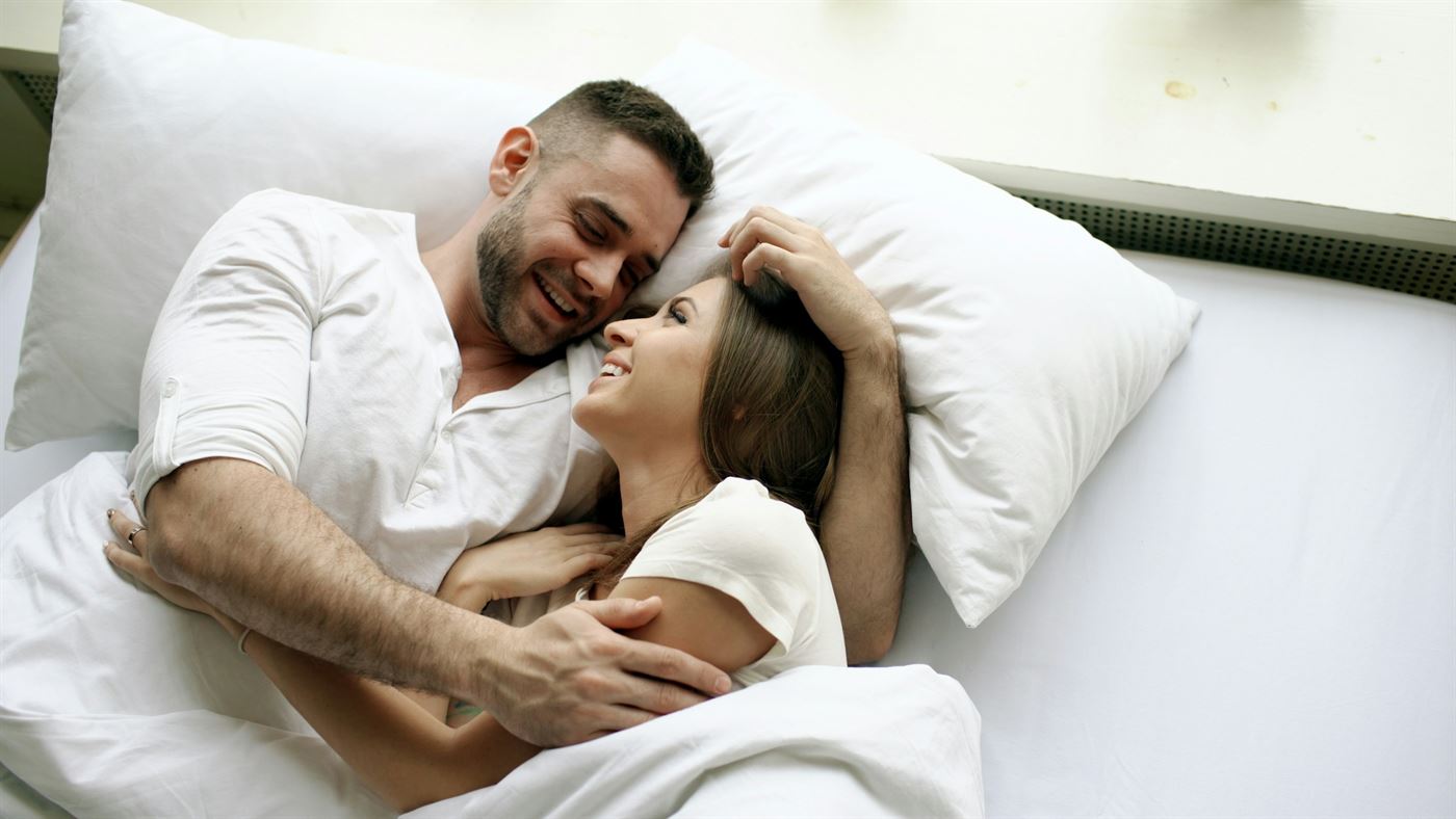 Couple relaxing comfortably in bed